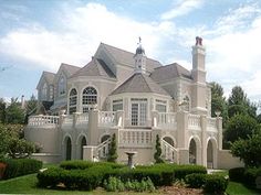 a large white house sitting on top of a lush green field