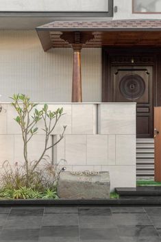 the front door of a house with a stone planter next to it