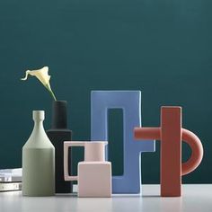 several different colored vases and bottles on a table