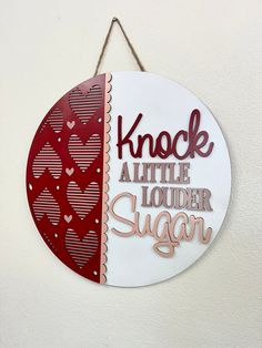 a sign that says knock all the louder sugar on it hanging from a wall