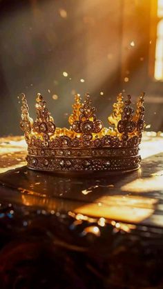 a gold crown sitting on top of a table next to a light shining through the window