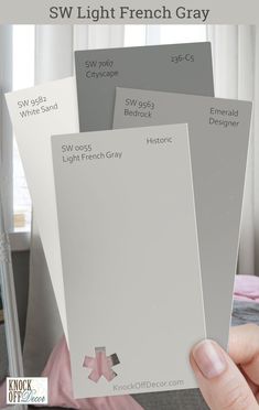 someone is holding up some gray paint swatches for their bedroom color scheme, so it's easy to use