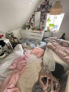 an unmade bed in a room with lots of clutter on the floor