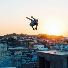 a man flying through the air while riding a skateboard in front of a sunset