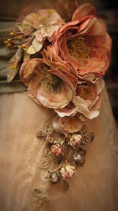 a close up of a dress with flowers attached to it's waistline and brooch