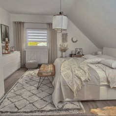 a bedroom with white bedding and rugs on the floor, windows in the ceiling