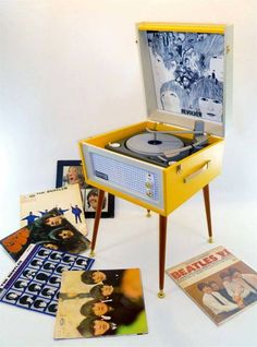 an old record player sitting on top of a table next to various records and cds