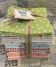 a stack of cloths sitting on top of a quilted tablecloth covered in polka dots