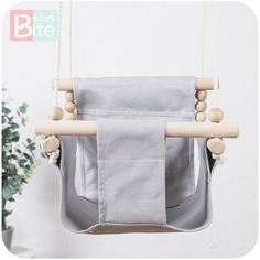 a grey bag hanging from a wooden frame