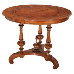 an old wooden table with three legs and a small round top on one end,