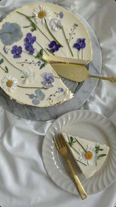 there is a piece of cake with flowers on it next to a fork and plate