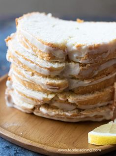 a stack of cake sitting on top of a wooden plate next to a slice of lemon