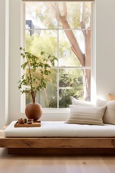 a living room with a large window and a couch in front of the windowsill