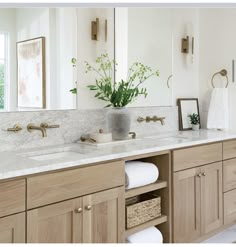 a bathroom with double sinks and marble counter tops