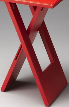 a red table with an x design on the top and one leg missing from it