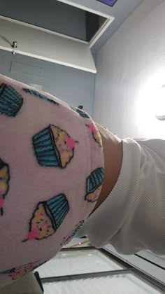 a woman's leg with cupcakes on it in front of a refrigerator