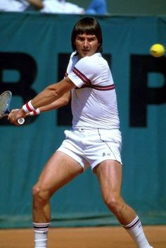 a man swinging a tennis racquet at a ball