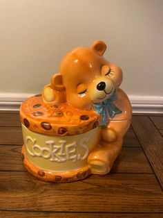 a ceramic teddy bear sitting on top of a cookie jar