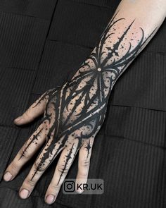 a person's hand with black ink on it and an intricate design in the middle