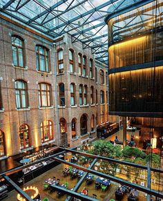 an atrium with tables and couches in the center, surrounded by glass ceilinging