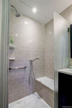 a walk in shower sitting next to a white sink and counter top under a mirror