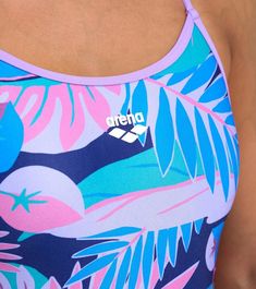 a close up of a person wearing a tank top with palm leaves on it and an arena logo