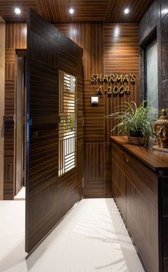 an entrance to a hotel with wood paneling and plants on the counter top in front of it