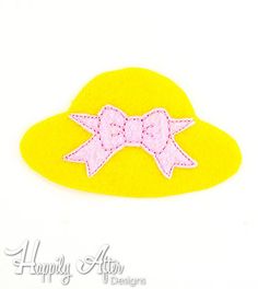 a yellow hat with a pink bow on it