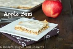 an apple bar is sitting on a white plate next to a baking pan and red apple