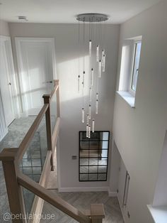 an overhead view of a staircase with chandelier hanging from it's ceiling