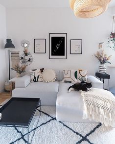 a living room filled with lots of furniture and pictures on the wall above it's couch