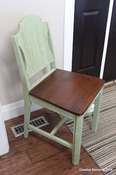 a wooden chair sitting on top of a hard wood floor next to a black door