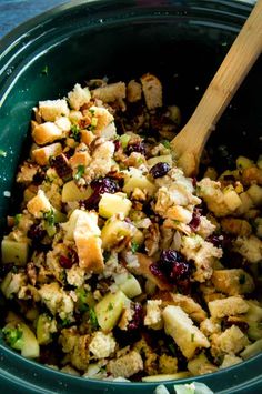 a green bowl filled with stuffing and cranberries