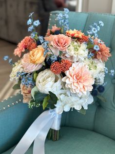 a bridal bouquet sitting on top of a blue chair