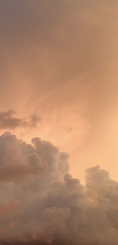 an airplane is flying in the sky with clouds