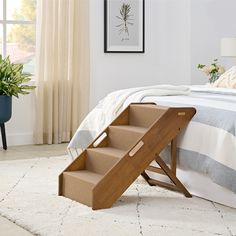 a bed room with a neatly made bed and a set of steps leading to the bed