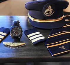 the uniform is blue with gold stripes and has a watch, tie, cufflinks, and lapel pin