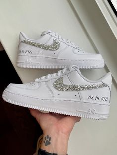 someone is holding up their white nike air force sneakers with silver sequins on them