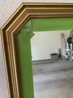 a mirror that has been painted green and gold