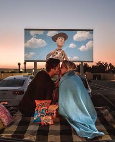 a man and woman kissing in front of a movie poster on the back of a car