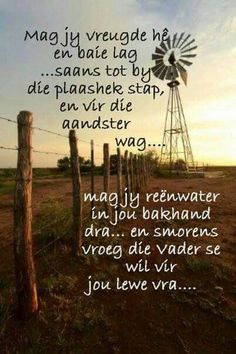 a poem written on the side of a fence with a windmill in the back ground