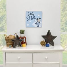 a white dresser with mickey mouse on it and other items sitting on top of it