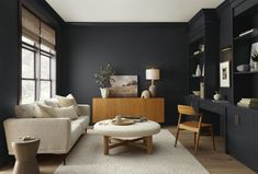 a living room with black walls and white carpeted flooring, furniture and decor