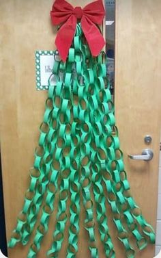 a christmas tree made out of green paper with a red bow on it's head