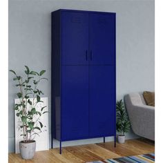 a blue cabinet next to a couch and potted plant in a room with hardwood floors