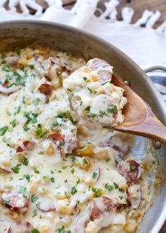 a skillet filled with pasta and meat covered in cheese, sauce and parsley