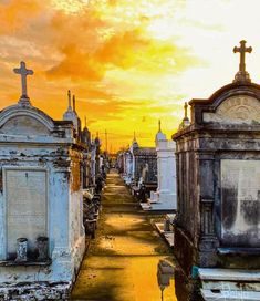 the sun is setting over an old cemetery