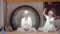 two women sitting on the floor in front of a gong