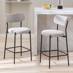 Elevate your kitchen or bar area with this modern 2-piece counter stool set. Crafted with a sleek, powder-coated iron frame in a black hue, they're paired with a comfy, upholstered seat in a polyester blend. The low back design adds a contemporary touch, while the built-in footrest ensures a cozy spot to perch. Plus, the plastic glides protect your floors from scratches. Whether you're enjoying breakfast or cocktails, these stools are ready to impress. Just remember to keep them looking fresh by Padded Bar Stools, Fabric Bar Stool, Counter Seating, Boucle Fabric, Modern Bar Stools, Modern Bar, Counter Bar Stools, Kitchen Bar Stools, Black Metal Frame