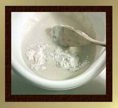 a wooden spoon in a white bowl filled with flour